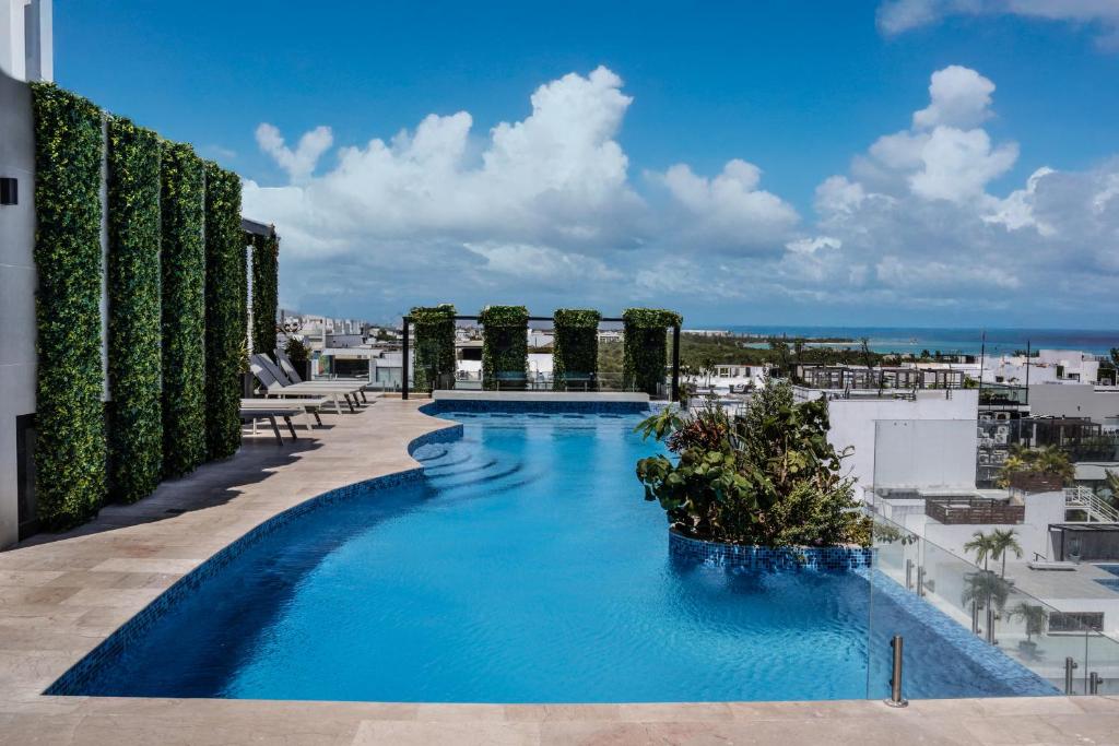 a swimming pool on the roof of a building at Luxury Condo en Menesse CocoBeach in Playa del Carmen