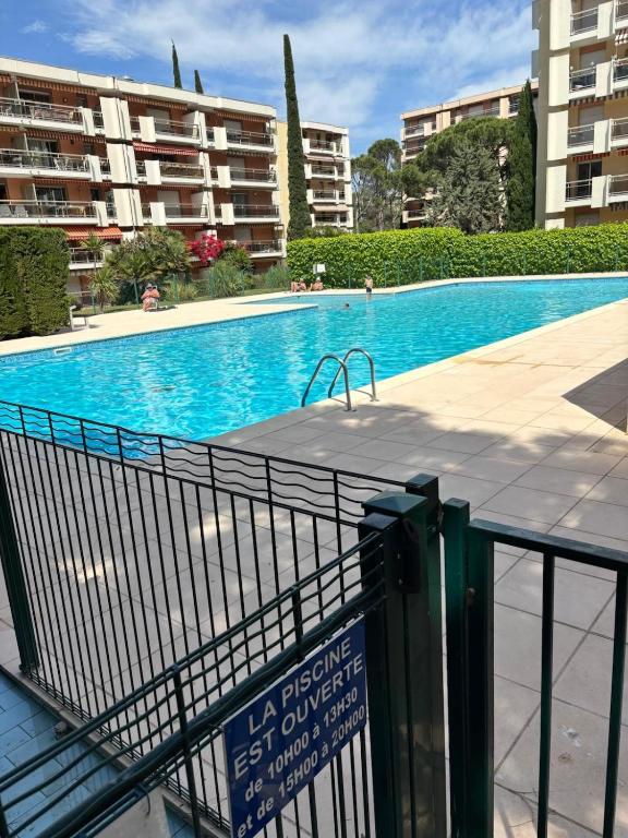 une piscine avec un panneau en face d'un bâtiment dans l'établissement Le refuge varois, à Saint-Raphaël