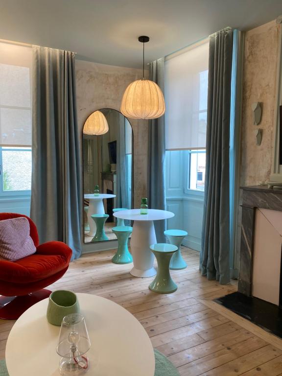 a living room with two tables and a mirror at Le studio Grande Maison Perrier in Montbrison