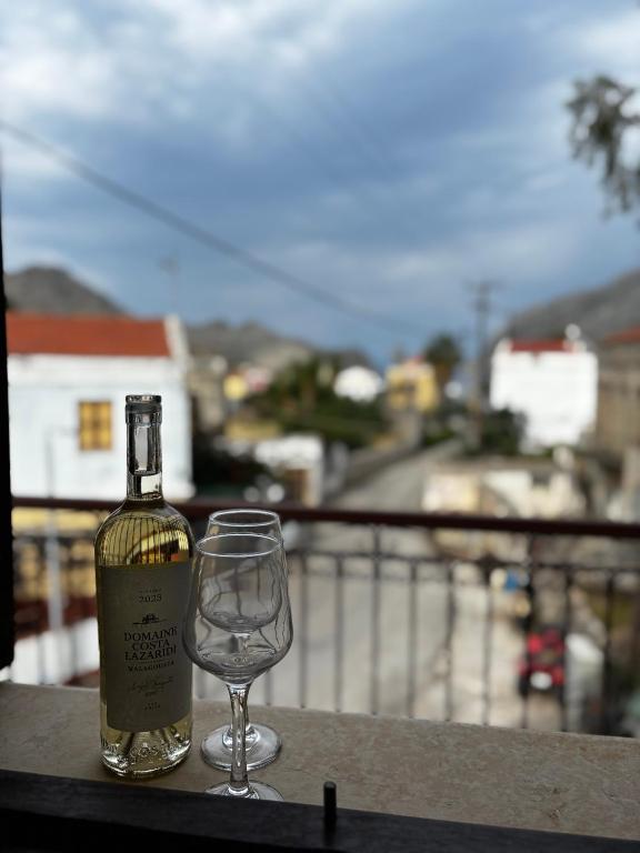 a bottle of wine and a wine glass on a balcony at Amelia's Home in Symi