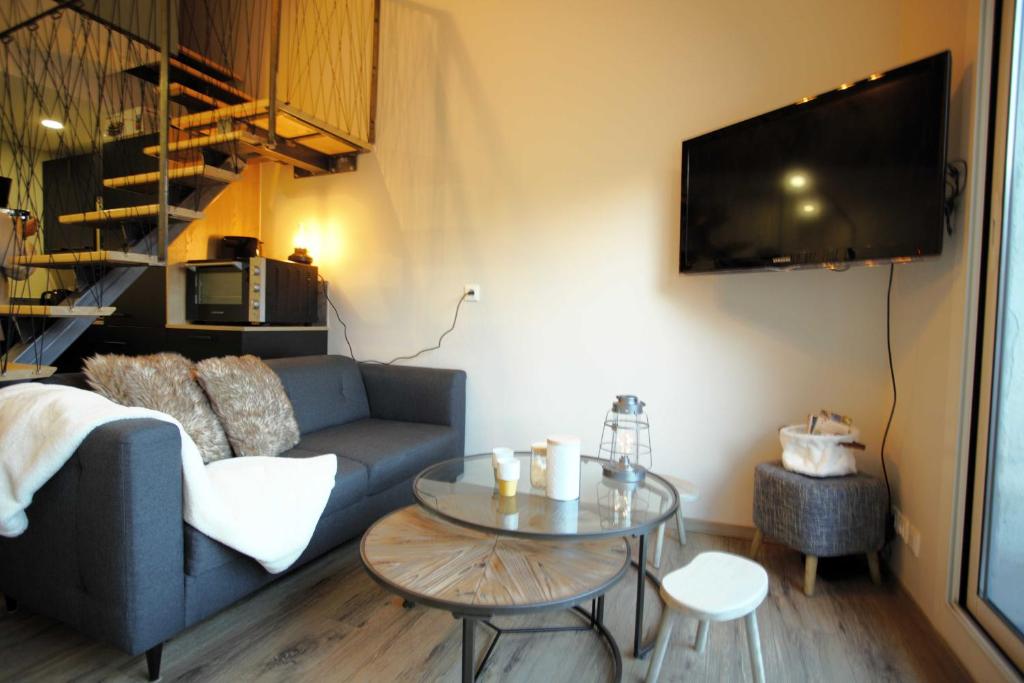 A television and/or entertainment centre at Le Duplex - Cosy & Vue Montagnes