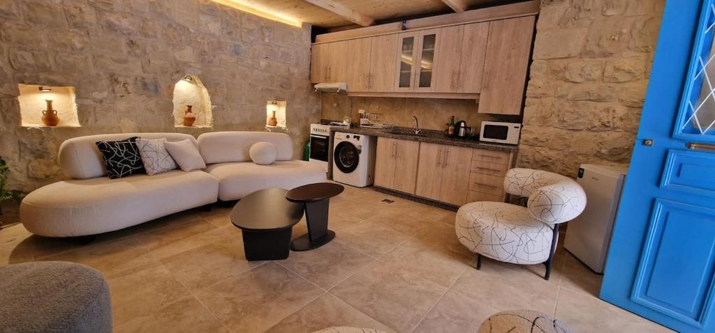 a living room with a white couch and a kitchen at Iris 2 BR Apartment In Batroun in Batroûn