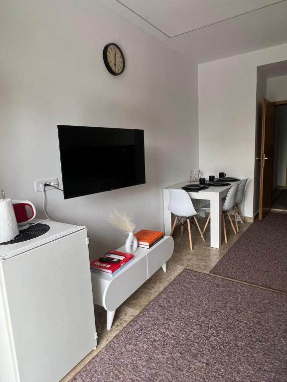 a white living room with a tv and a table at Apartman Z13, Ljubuški in Ljubuški