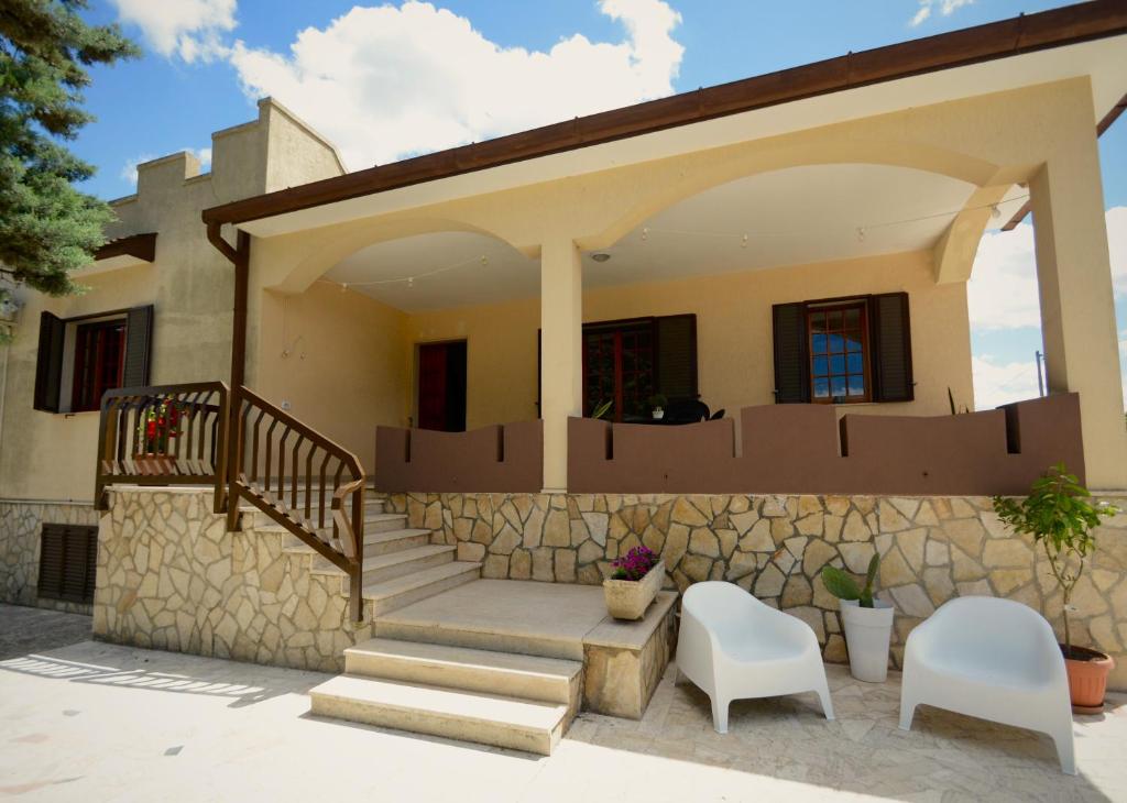 a house with a staircase and two white chairs at Terrarossa in Crispiano