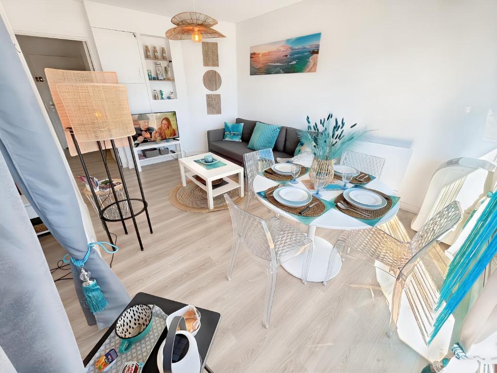 un salon avec une table et des chaises dans l'établissement La croisette - à 50 mètres de la plage de Juno Beach avec Balcon et Stationnement gratuit, à Bernières-sur-Mer