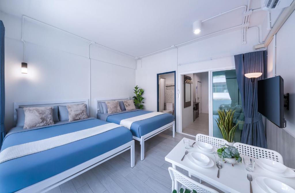 a hotel room with two beds and a table at Petchaburi22 Apartments next to Platinum mall in Bangkok