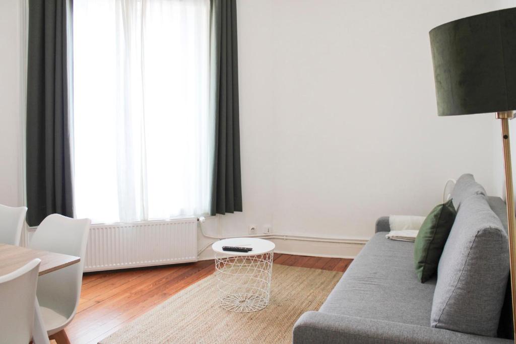 un salon avec un canapé et une table dans l'établissement Confort aux Portes de Paris - 5 pers near Subway, à Aubervilliers