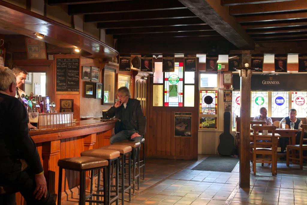 Un uomo seduto al bar che parla al cellulare di Murphys of Killarney a Killarney