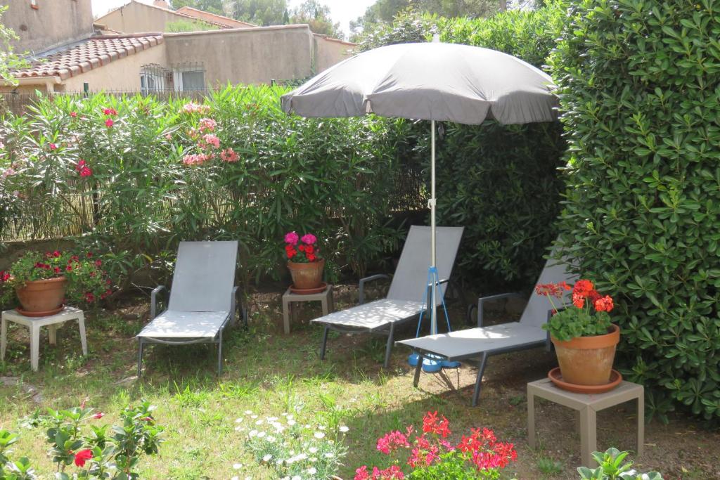 - un ensemble de chaises et d'un parasol dans le jardin dans l'établissement La Péguière, à Saint-Raphaël