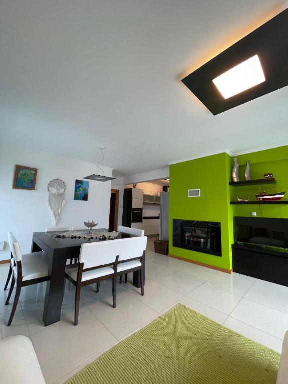 a living room with a table and a green wall at Oásis da Praia in Bicas