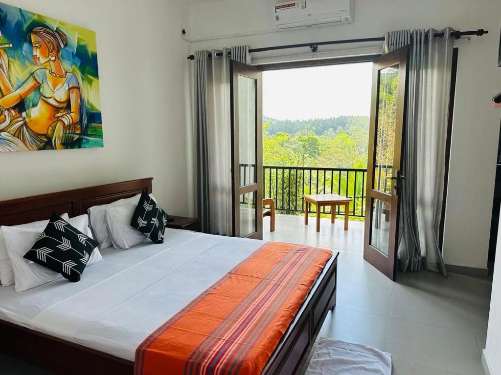 a bedroom with a king sized bed and a balcony at Grand Hills kandy in Kandy