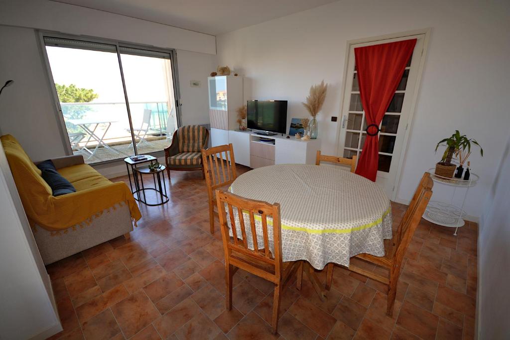 un salon avec une table et des chaises et une cuisine dans l'établissement magnifique T3 vue mer et direct plage, à Arcachon