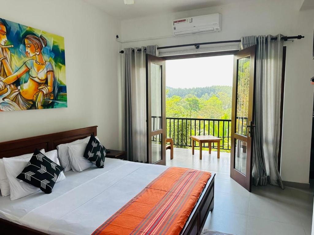 a bedroom with a bed and a view of a balcony at Grand Hills kandy in Kandy