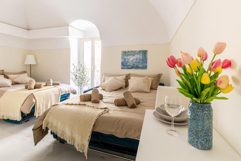 a bedroom with two beds and a vase of tulips at APARTAMENT ANNA - Julia Vieste in Vieste