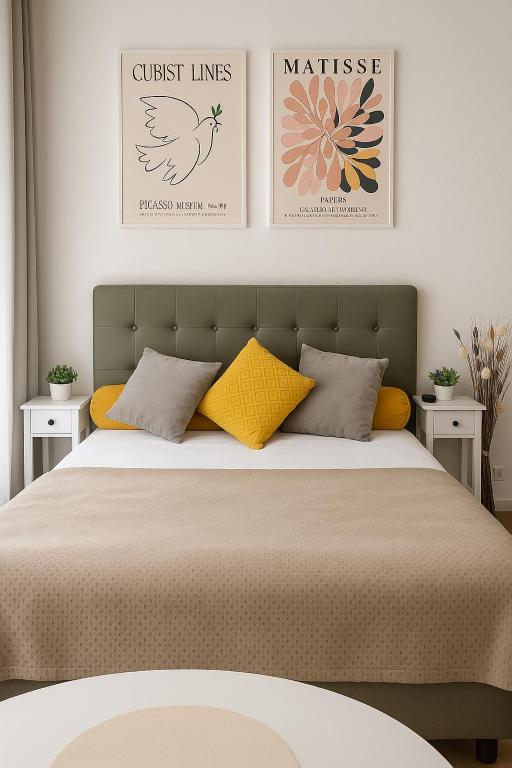 une chambre avec un lit avec deux tableaux au mur dans l'établissement Paris à 7 minutes en métro, à Rosny-sous-Bois