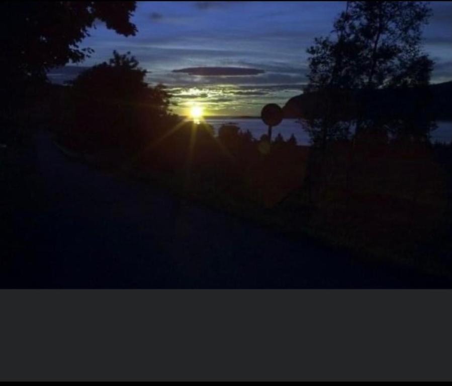 ein Sonnenuntergang mit der Sonne über dem Wasser in der Unterkunft Ingeborgstova in Lii