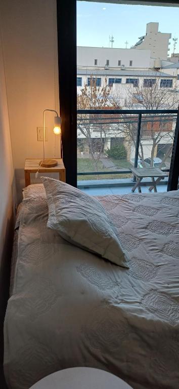 a bedroom with a bed and a large window at Alquilercipolletti in Cipolletti