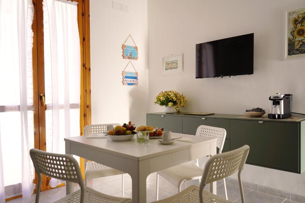 a dining room with a white table and chairs at Casa Marisa Design by the Sea in Torre Saracena