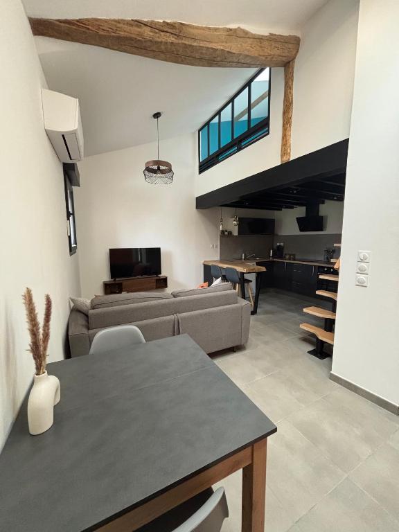 un salon avec un canapé et une table dans l'établissement Appartement cosy et équipé, à Saint-Porquier