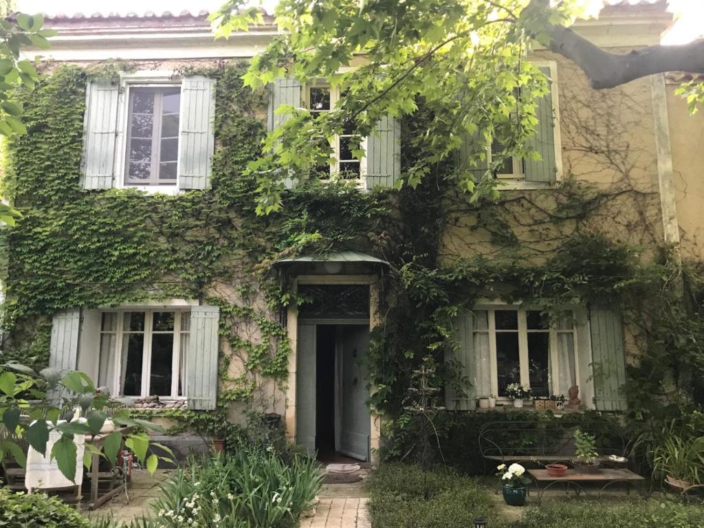 une vieille maison avec du lierre sur le côté dans l'établissement Le Mas de l'Embellie, à Arles