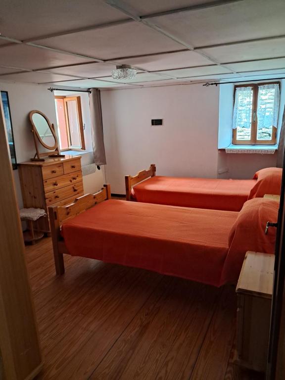 sypialnia z 2 łóżkami, komodą i lustrem w obiekcie CA DUL DALU w mieście Baceno