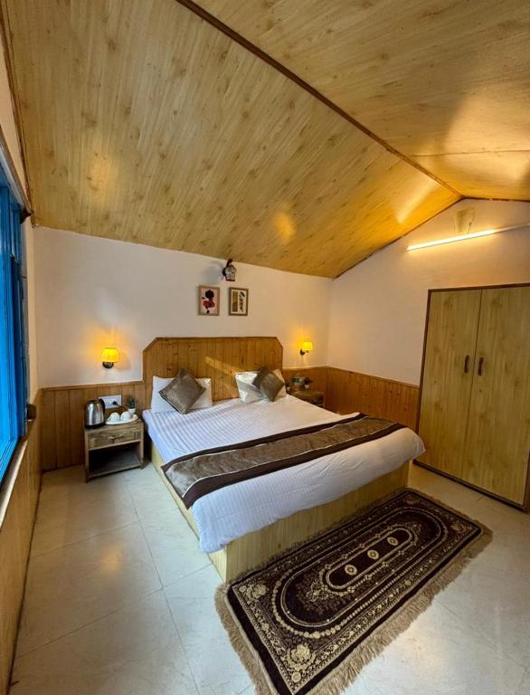 una grande camera da letto con un grande letto e un tappeto di Hostello Manali a Manāli