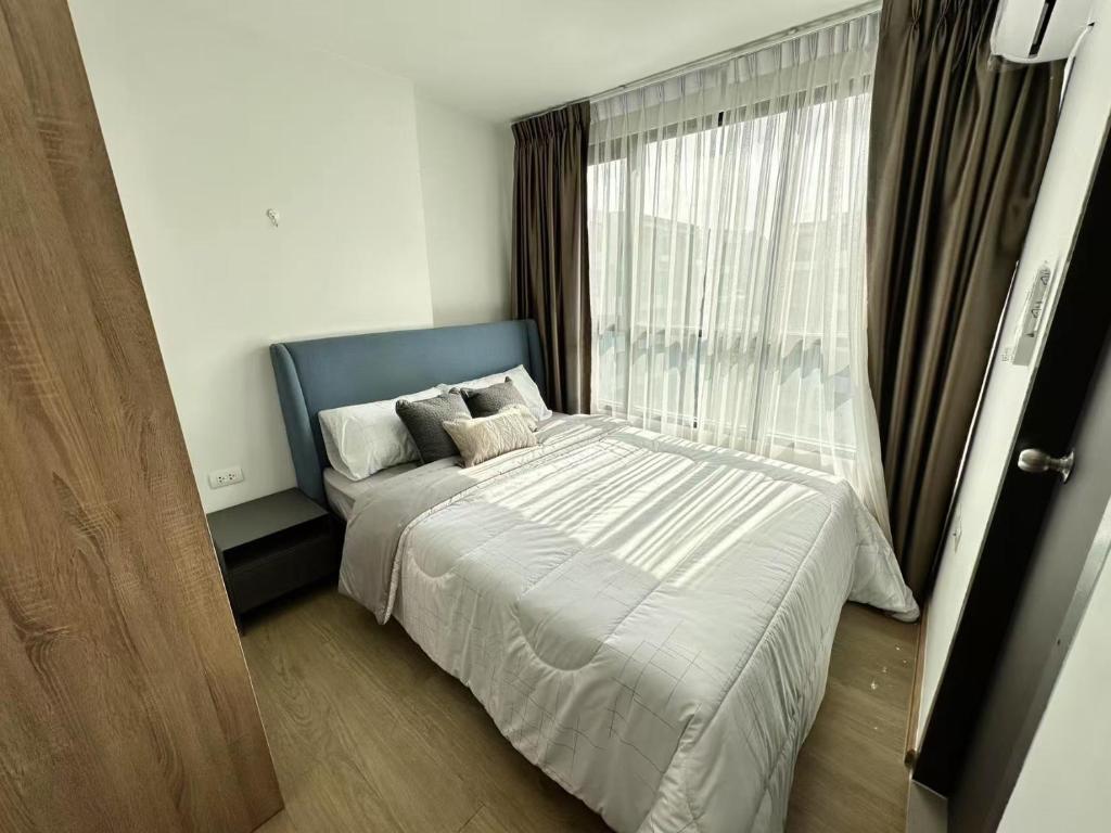 a bedroom with a bed and a large window at Centrio 2 bed rooms in Ban Nong Chaeng