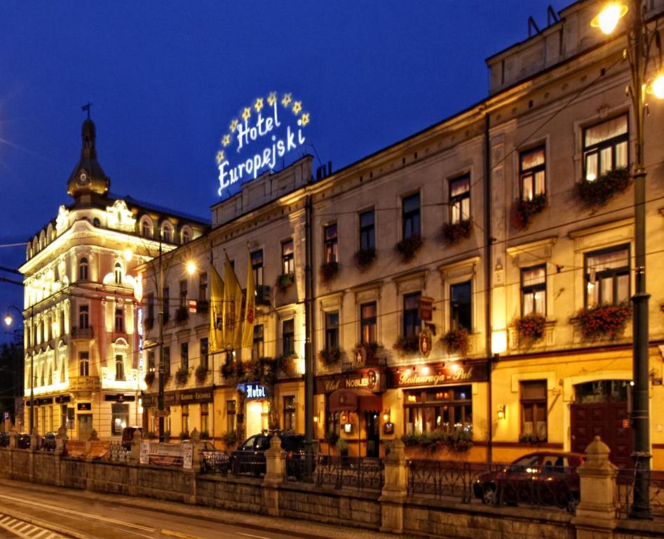 budynek z znakiem na górze w nocy w obiekcie Hotel Europejski w Krakowie