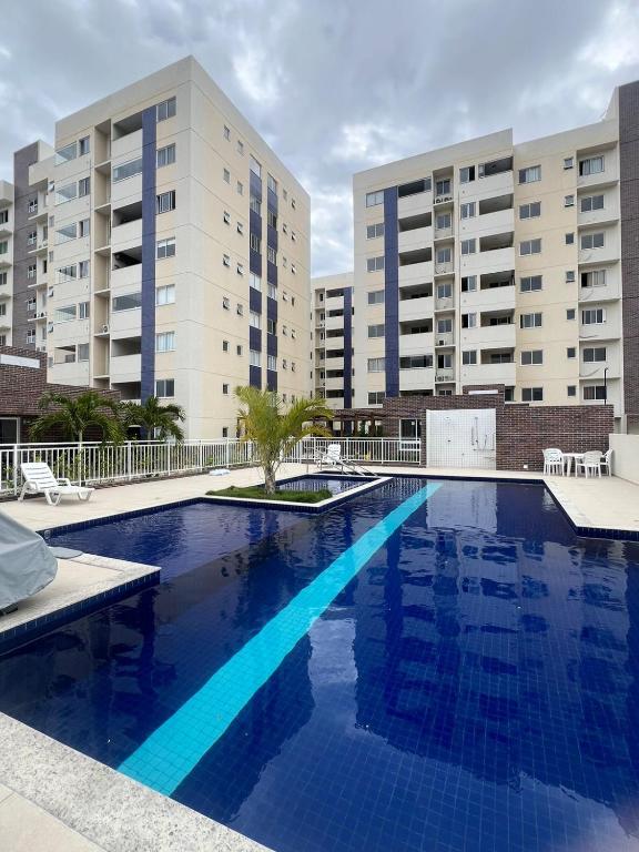 a large swimming pool in front of two tall buildings at Condomínio Club Resort 2 quartos com ar na melhor da Aruana in Aracaju