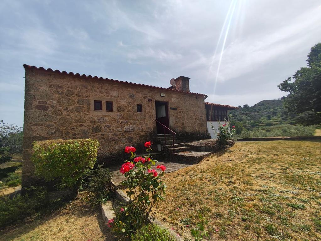 a stone building with flowers in front of it at Quinta de Gonçalo in Guarda