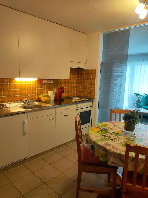 a kitchen with a table and a kitchen with a table and chairs at Pfeiren Leukerbad in Leukerbad