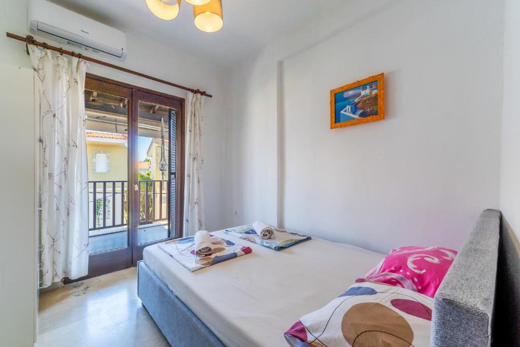 a small room with a bed and a window at Sunrise Pefkochori in Pefkohori