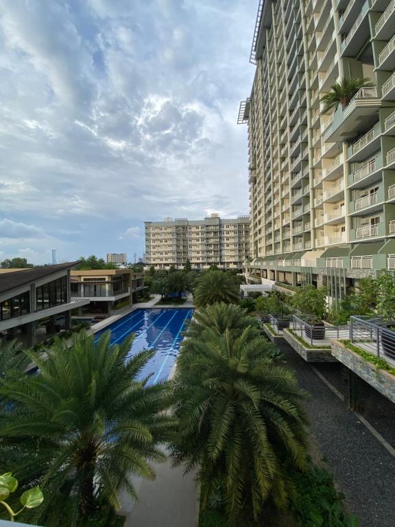 a swimming pool with palm trees in front of buildings at Condominium Luxury 1 bedroom, impressive amenities in Davao City