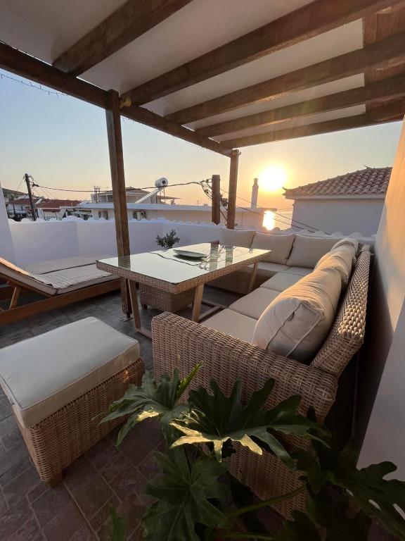 a patio with a couch and a table on a roof at Maroulios Apartment in Elafonisos
