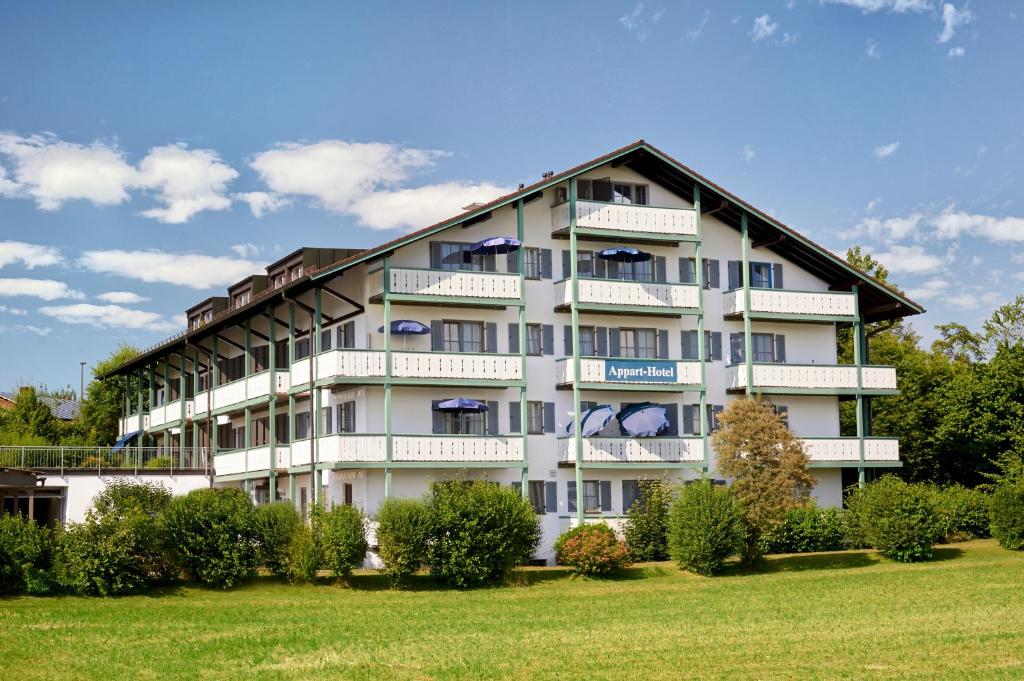 a large white building with bushes in front of it at Apparthotel Garni Superior Simsseeblick in Bad Endorf
