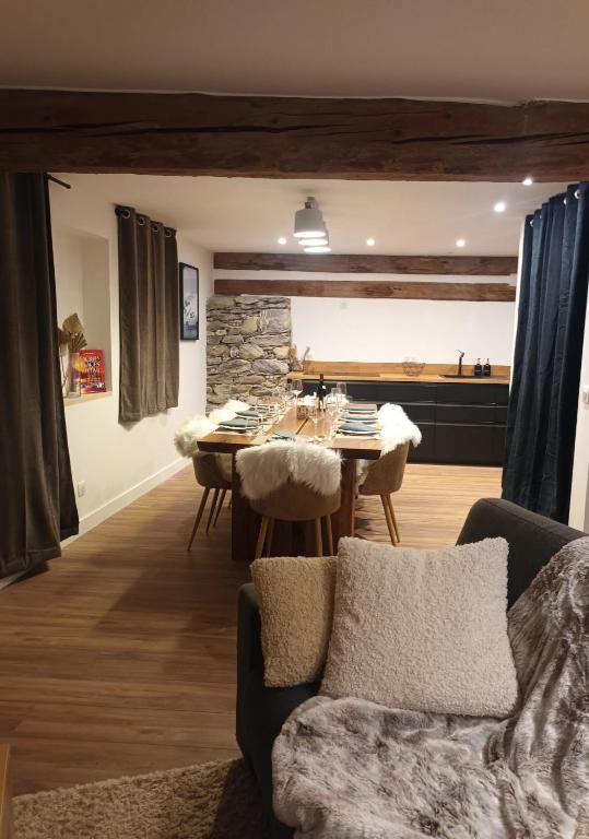 un salon avec une table et une cuisine dans l'établissement Chalet Serine et Barbarine au cœur des 3 Vallées pour 10, à La Combe