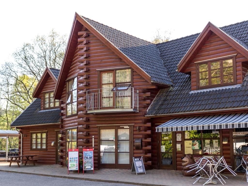 uma cabana de madeira com um telhado preto em Silkeborg Sø Camping Apartments em Silkeborg