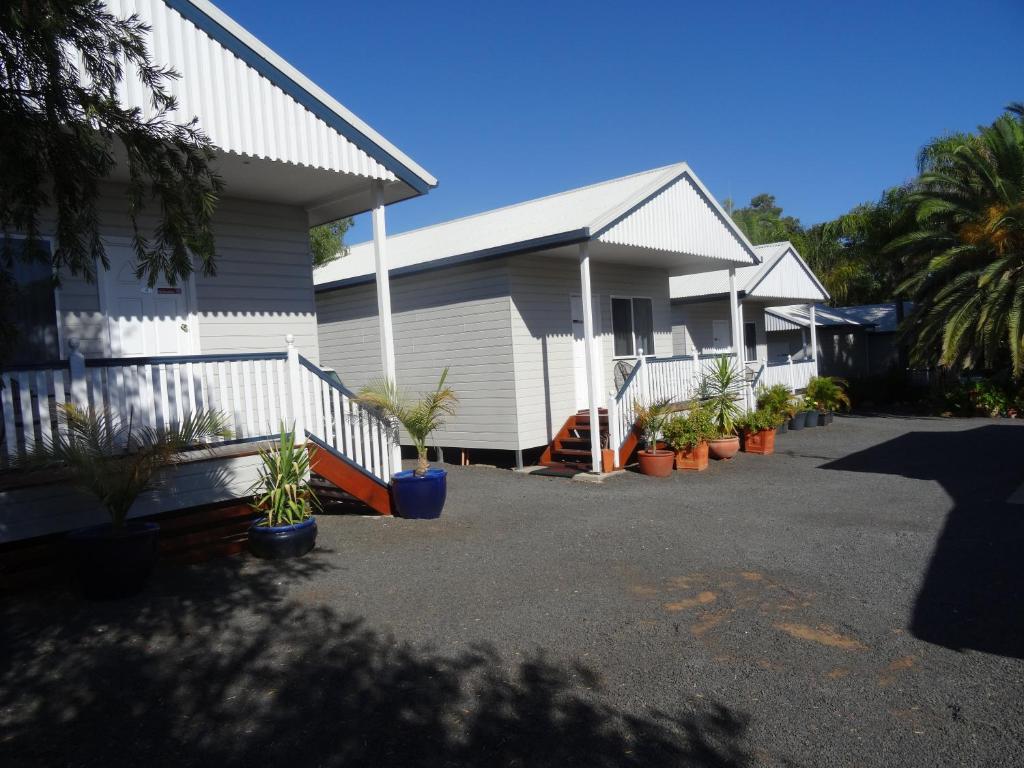 a house with potted plants in front of it at Augathella Palms Motel in Augathella