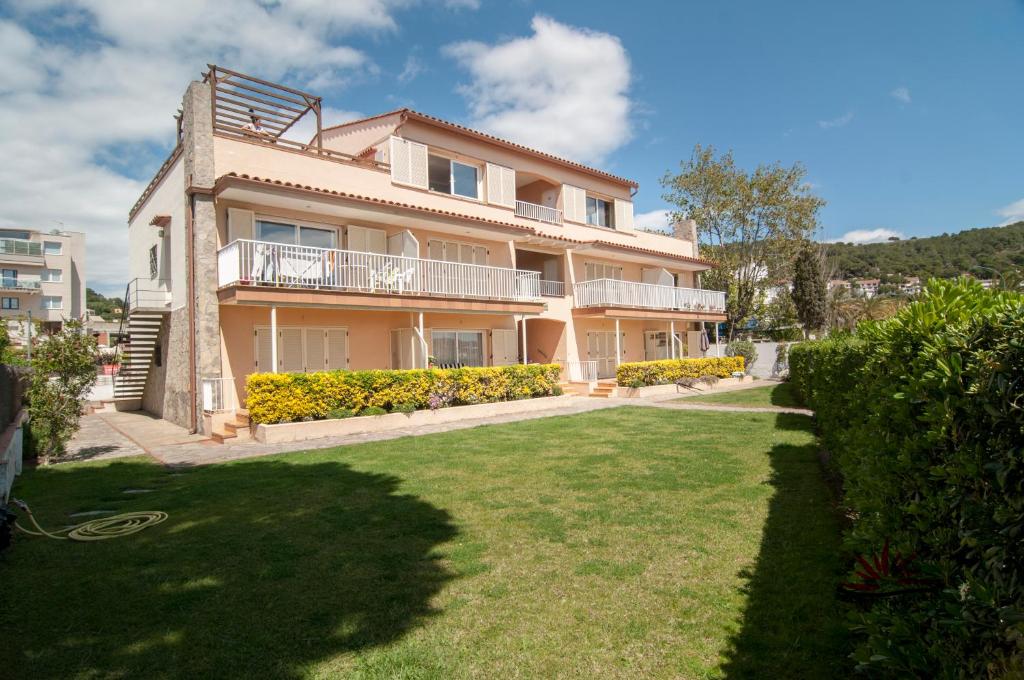 uma casa grande com um relvado em frente em Seafront L'Estartit Apartments em L'Estartit