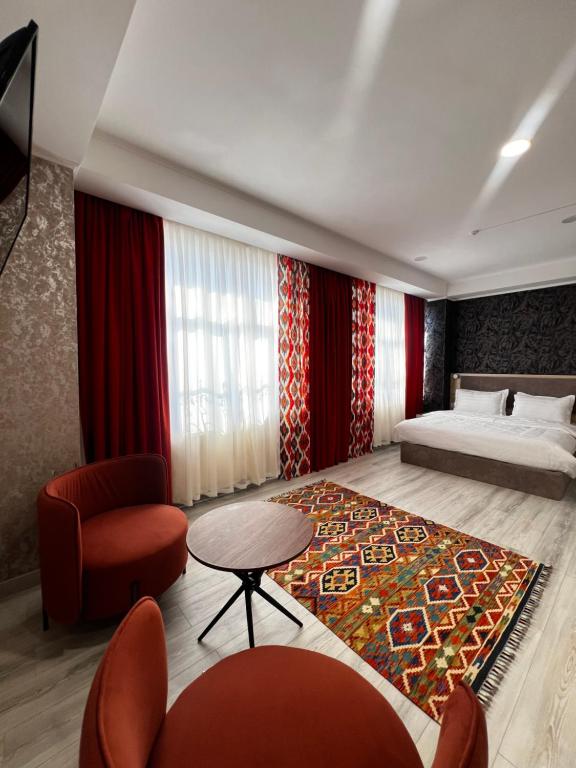 a bedroom with a bed and a table and a rug at Badyan Boutique Hotel in Bukhara in Bukhara