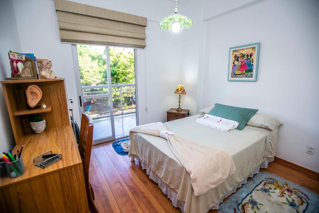 a small bedroom with a bed and a window at Condomínio Praia de Itapuã - Recreio in Rio de Janeiro