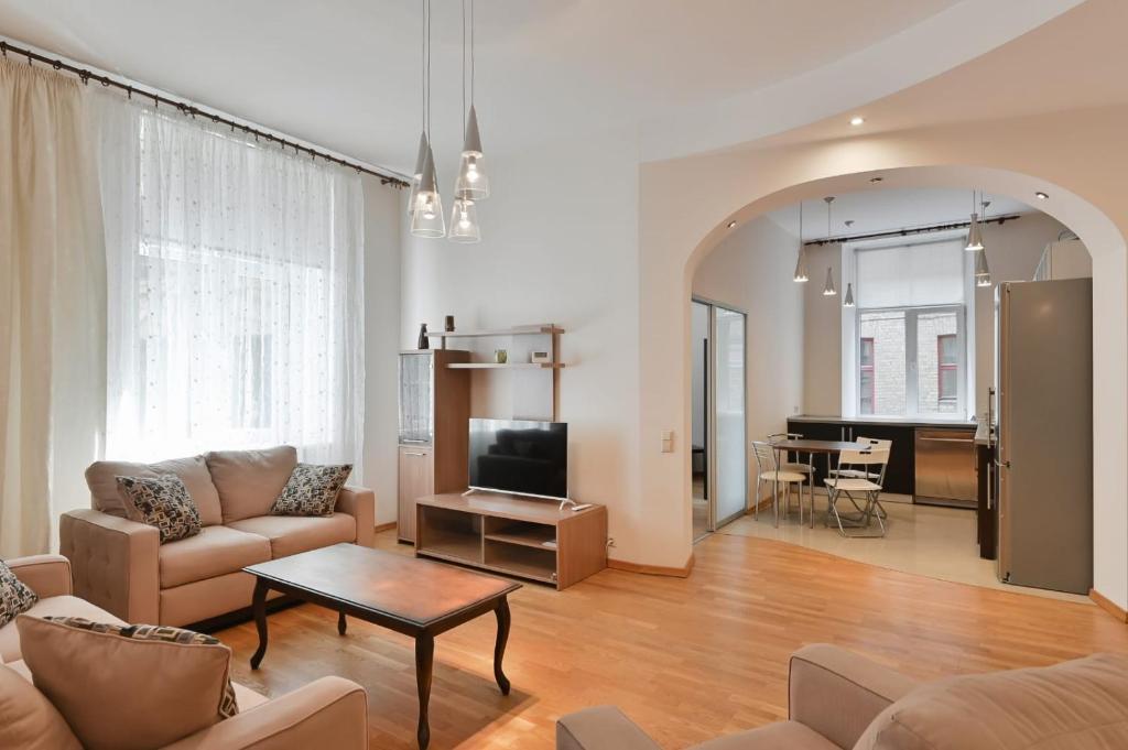 a living room with a couch and a tv at Spacious 82 m2 2 bedroom Flat and Roof Terrace in the Heart of Riga in Rīga