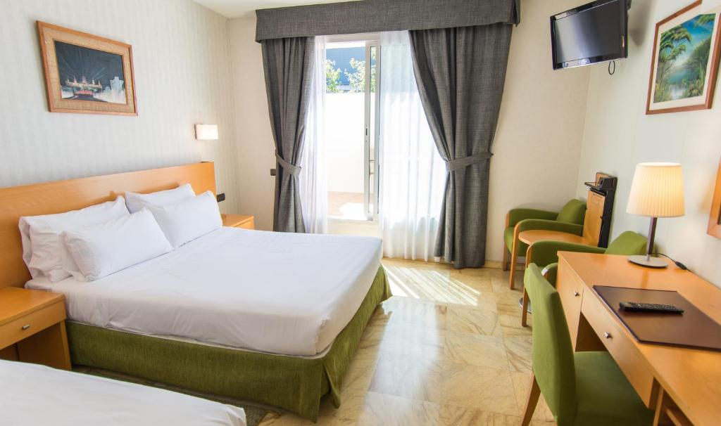 a hotel room with two beds and a television at Flor Parks in Barcelona