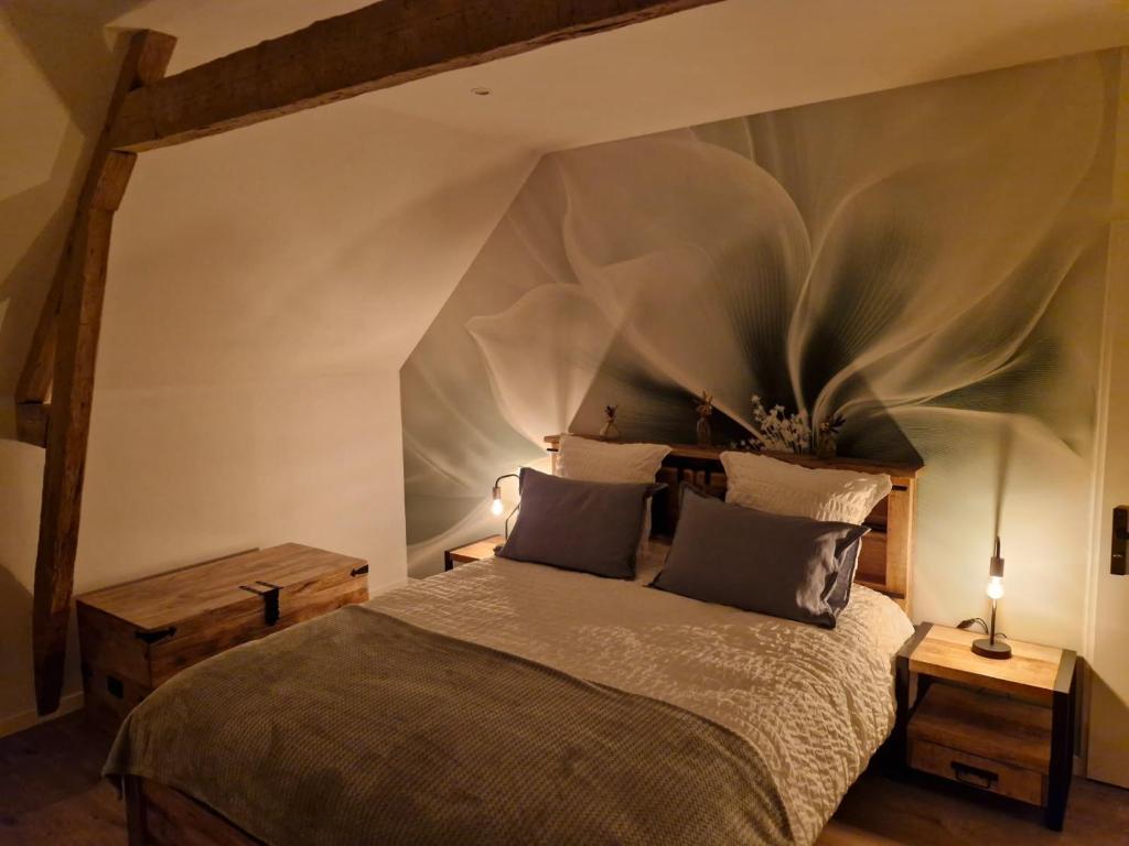 een slaapkamer met een groot bed en 2 tafels bij Gîte du Bois l'Abbé in Saint-Martin-Boulogne