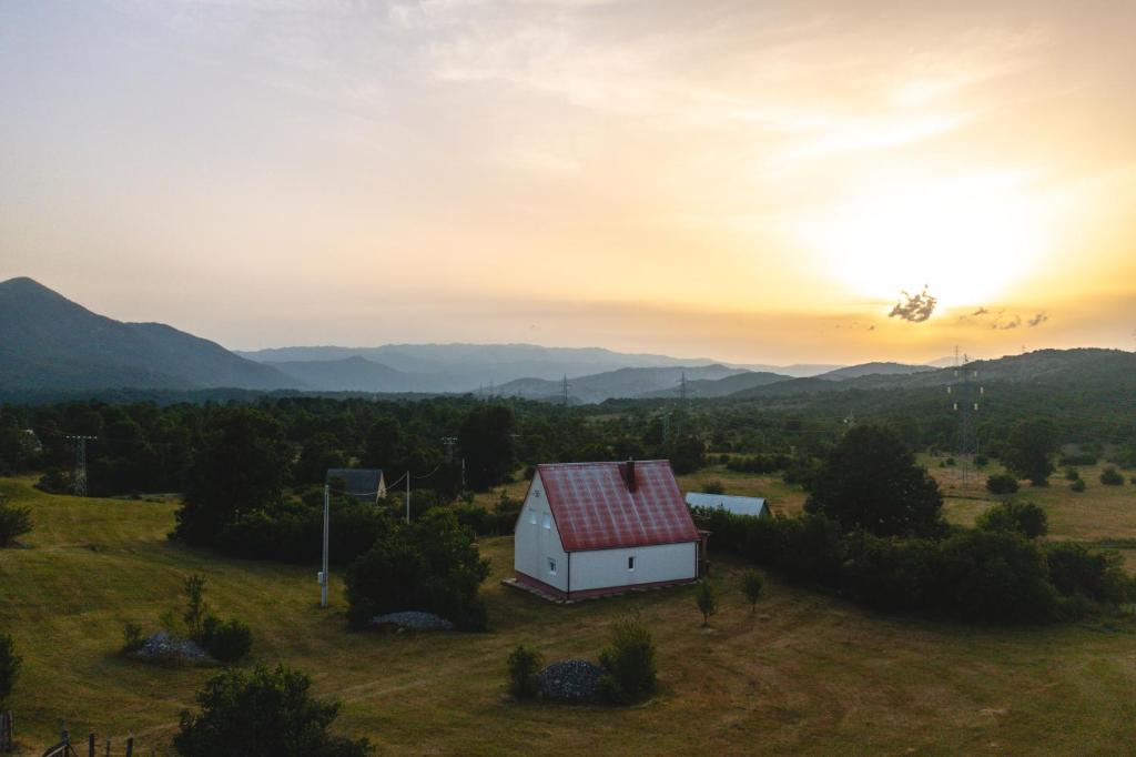 a barn in a field with the sunset in the background at House Duzi in Duži