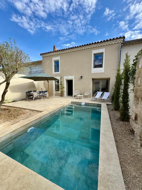 une piscine devant une maison dans l'établissement Maison de ville piscine chauffée, à Eyragues