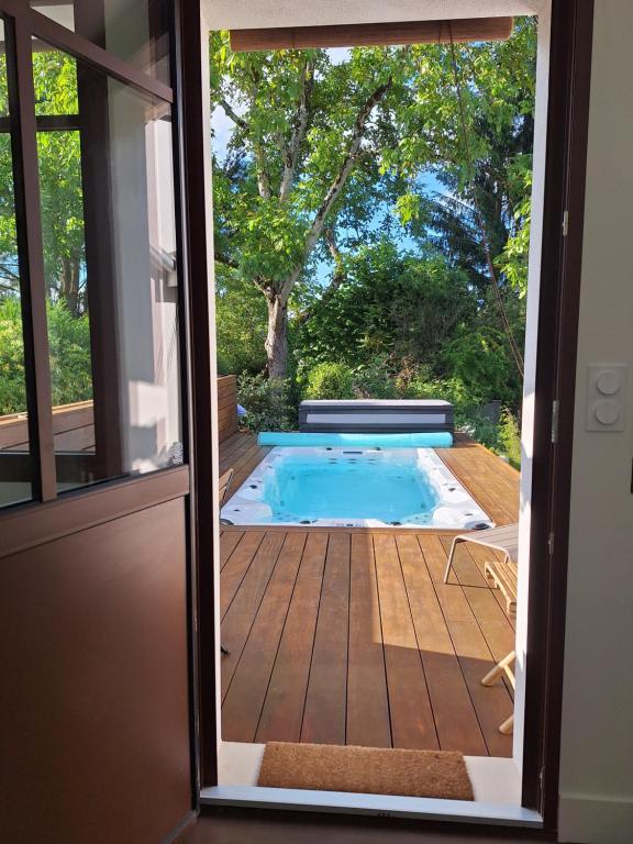 une porte menant à une piscine avec une terrasse dans l'établissement Studio de charme et spa de nage, à La Celle-sous-Gouzon