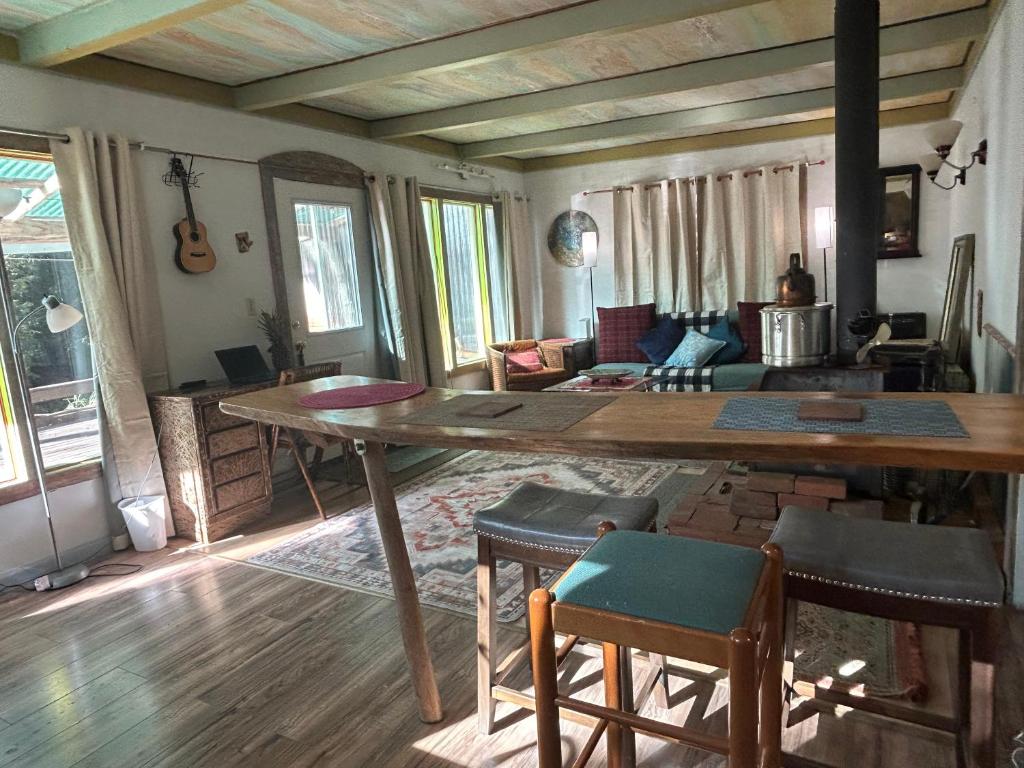 ein Wohnzimmer mit einem großen Holztisch und Stühlen in der Unterkunft Chillshack in Abbeyville