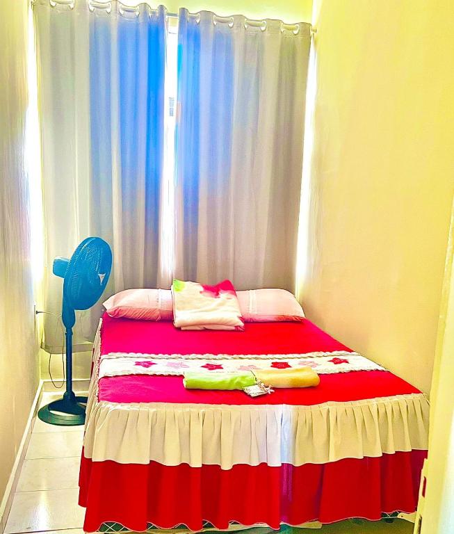 a bedroom with a bed with a red and white blanket at APTO 114 COMPARTILHADO Centro in Araguaína