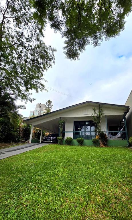a building with a green lawn in front of it at Alpen Haus - Ideal para família e grupo in Santa Rosa